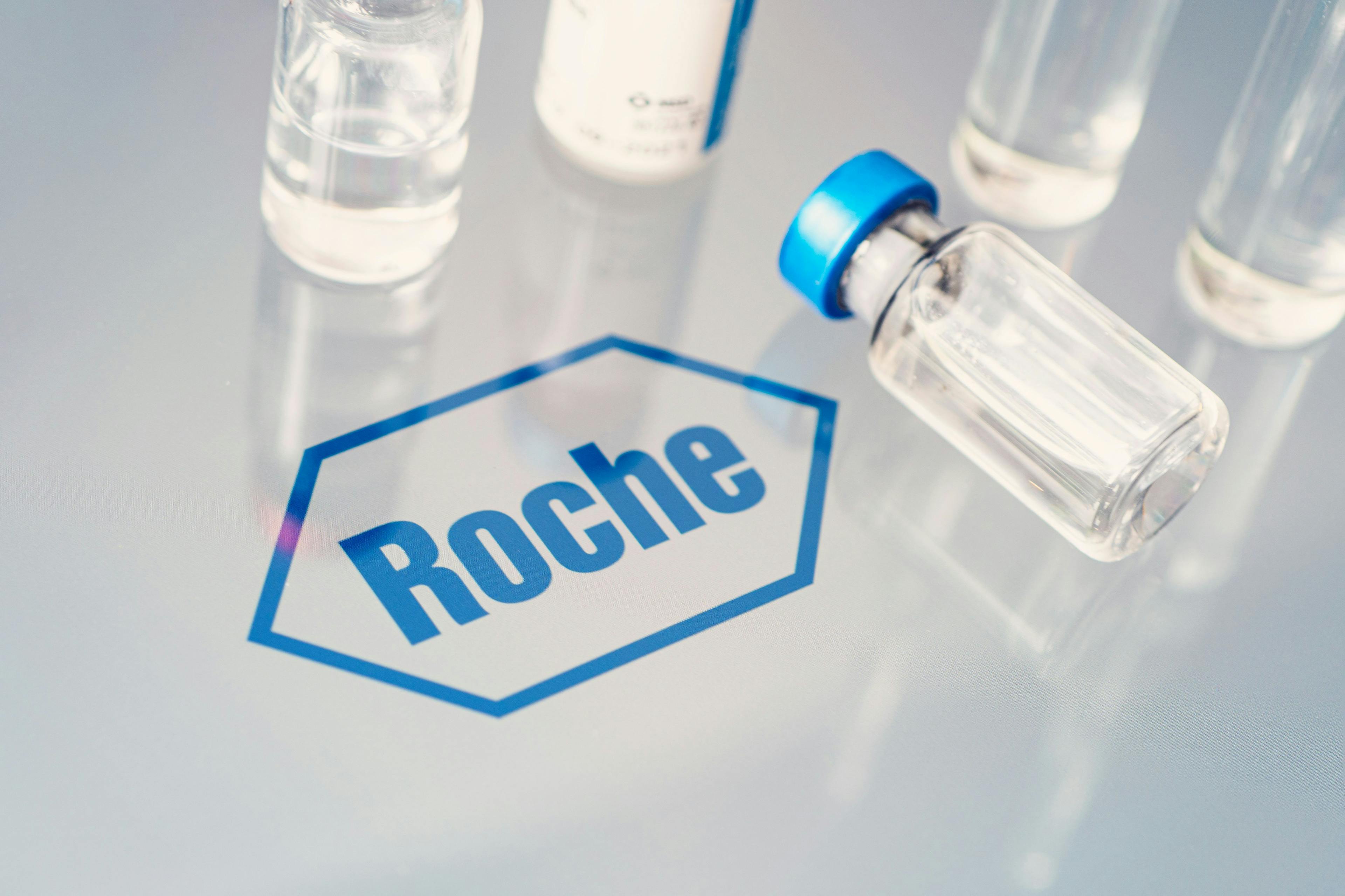 Vials of liquid on a white table and the logo of a large pharmaceutical company Roche.