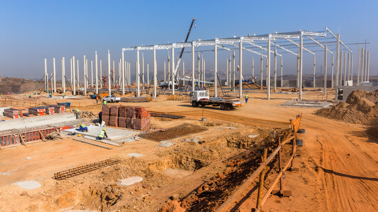Industrial Construction Site New Warehouse Factory Building concrete columns with steel roof beams attached to structure. Image Credit: Adobe Stock Images/ChrisVanLennepPhoto