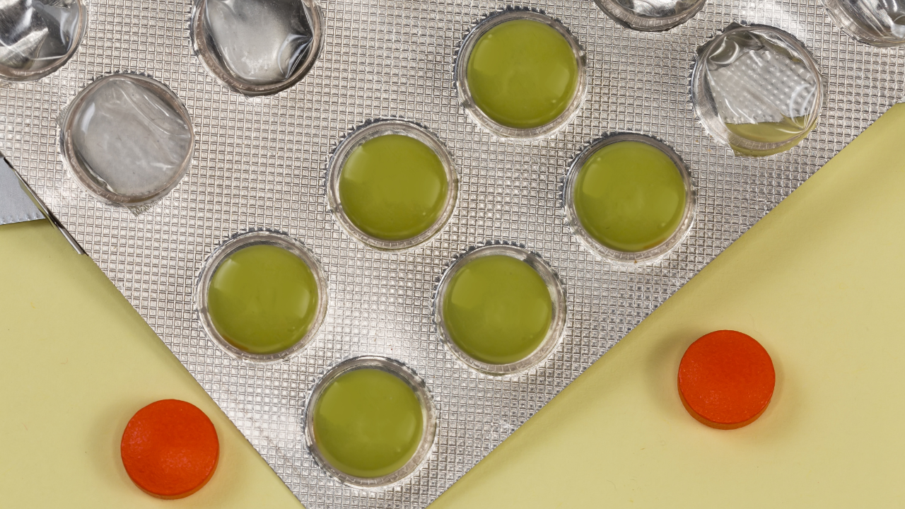 Green pills in blister pack, red pills separately, top view. Image Credit: Adobe Stock Images/An-T