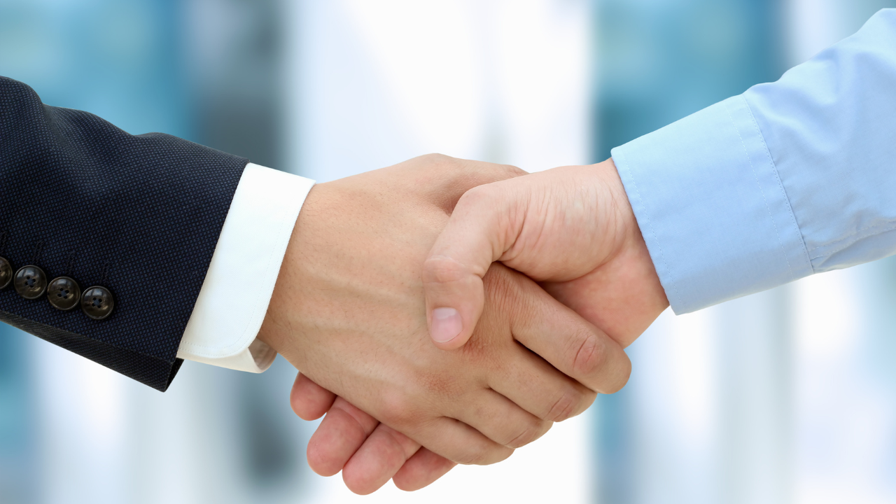 Close-up image of a firm handshake between two colleagues. Image Credit: Adobe Stock Images/Saklakova